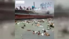 کمک مردم برای خالی کردن بار لنج آتش‌گرفته در بندر گناوه